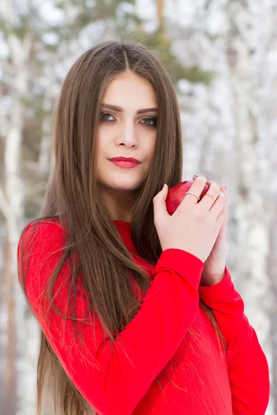 Young girl in a red dress with an apple in his hand — Stock Photo, Image