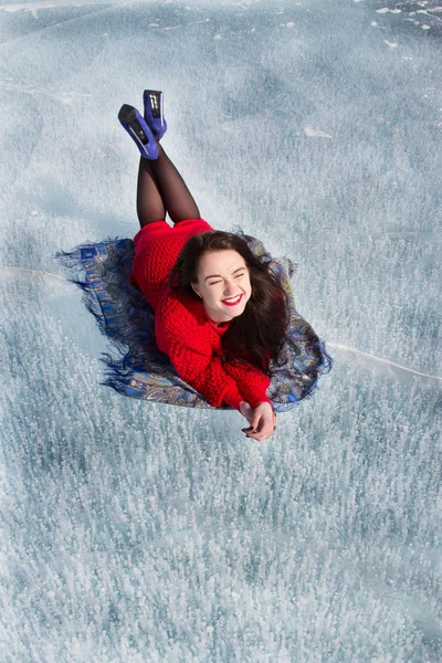 Fiatal lány, egy piros ruhás, feküdt a jégen, a Bajkál-tó — Stock Fotó