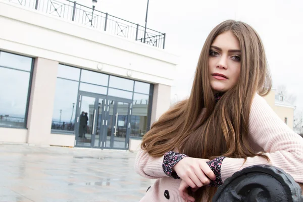 Jeune femme d'affaires assise sur un banc sur le fond de l'immeuble de bureaux — Photo