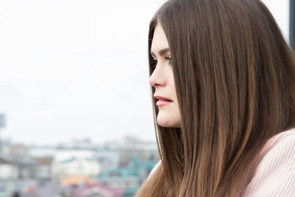 Ragazza dai capelli lunghi sullo sfondo della città — Foto Stock