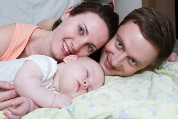 Happy parents near a sleeping baby — Stock Photo, Image