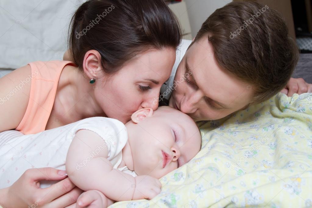 Happy parents near a sleeping baby — Stock Photo © MomSirk 104513048