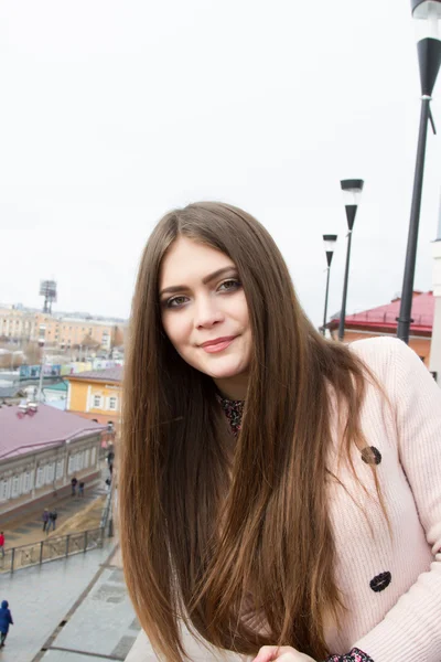 Young girl with long hair on the background of the modern city — Stock Photo, Image