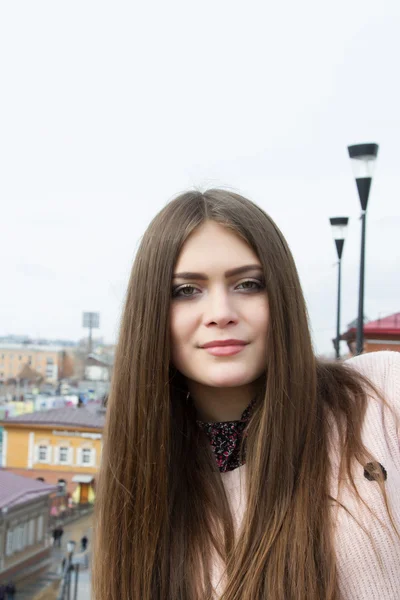 Young girl with long hair on the background of the modern city — Stock Photo, Image