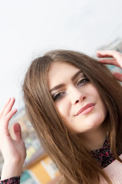 Chica joven con el pelo largo en una ciudad moderna — Foto de Stock