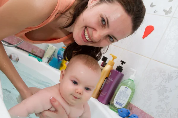 Мати купає маленьку дитину у ванній — стокове фото