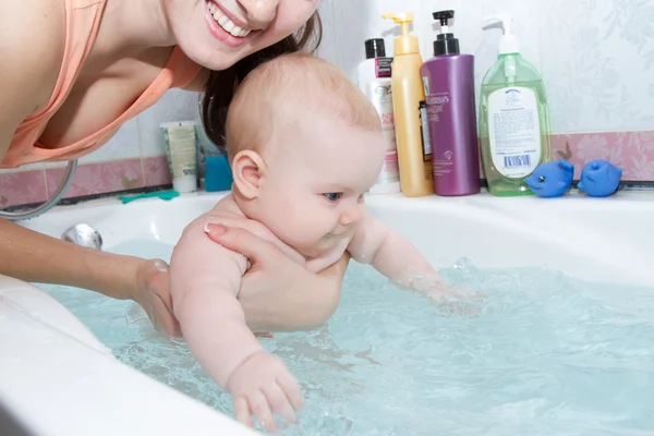 Мати купає маленьку дитину у ванній — стокове фото