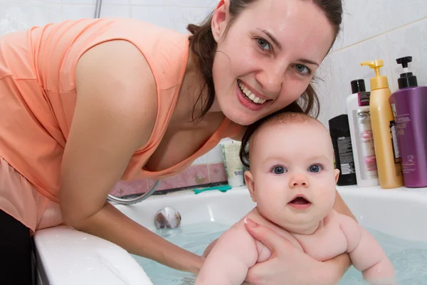 Madre bañando a un niño pequeño en el baño — Foto de Stock
