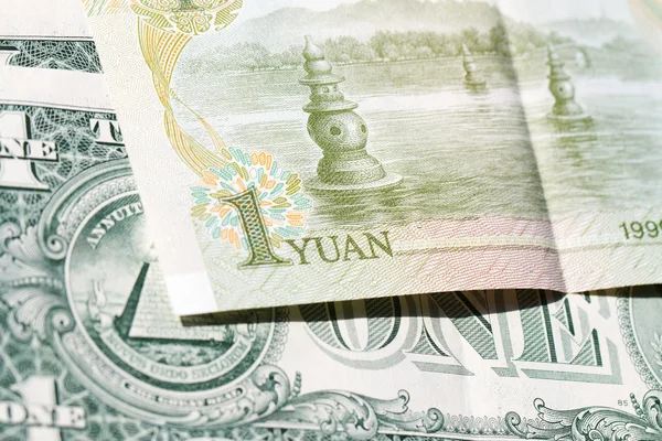 Un yuan chino con el telón de fondo de un dólar estadounidense — Foto de Stock