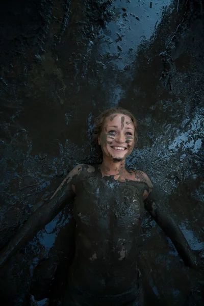 Happy young girl taking a mud treatment — Stock Photo, Image