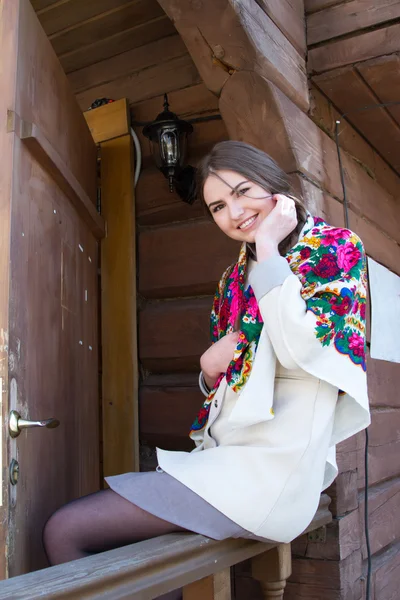 Девушка с банданой на фоне деревянного дома — стоковое фото