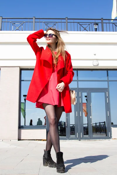 Podnikání žena v červeném kabátě na pozadí kancelářská budova — Stock fotografie