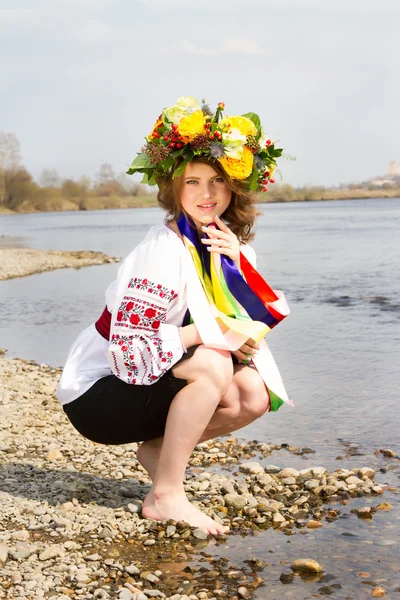 Девушка в вышитой рубашке и с венком цветов на голове — стоковое фото