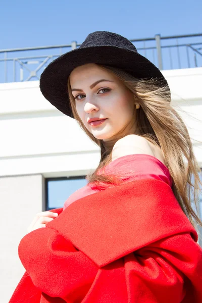 Mädchen in rotem Mantel auf dem Hintergrund des Business Centers — Stockfoto