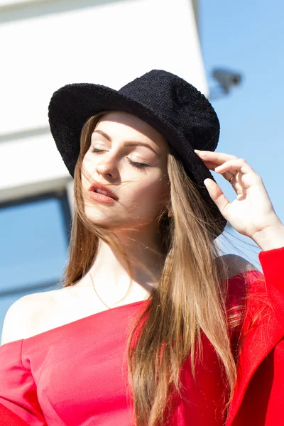 Young girl in a black hat and red dress — Stock Photo, Image