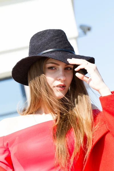 Young girl in a black hat and red dress — Stock Photo, Image