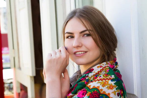 Flicka med en bandana mot bakgrund av ett trähus — Stockfoto