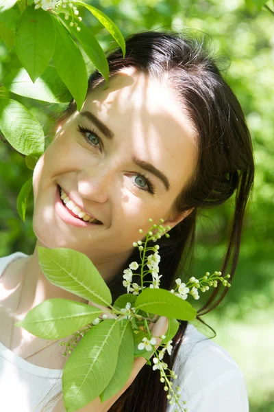 Flicka på en bakgrund av en blommande fågel körsbär — Stockfoto