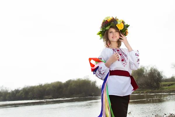 Girl in an embroidered shirt and a wreath on his head standing on the river bank — Stock Photo, Image