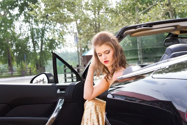 Meisje zittend in de bestuurdersstoel in een cabrio — Stockfoto