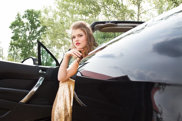 Chica sentada en el asiento del conductor en un convertible — Foto de Stock