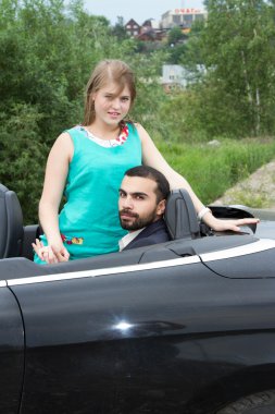 İki sevgili salon üstü açık arabayla karşılamak.