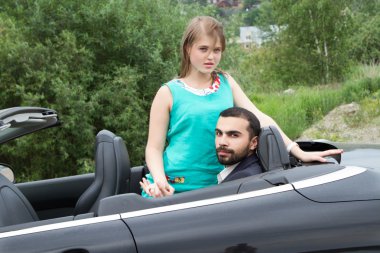 İki sevgili salon üstü açık arabayla karşılamak.