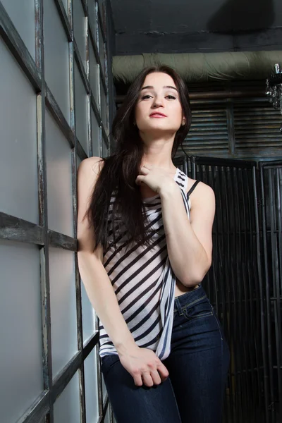 Girl in striped shirt standing near a huge window — Stock Photo, Image