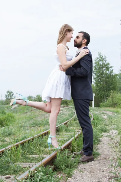 Two lovers are walking on railroad tracks — Stock Photo, Image