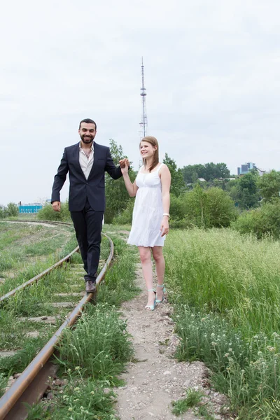 Dois amantes estão andando em trilhos ferroviários — Fotografia de Stock