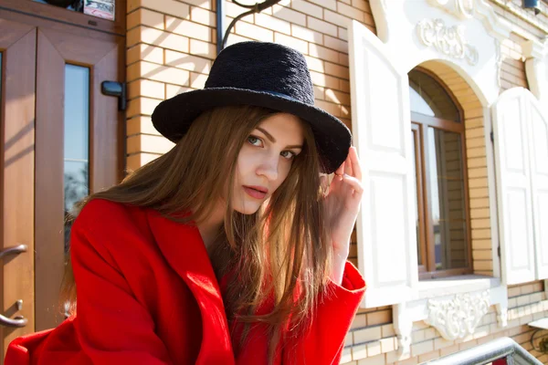 Piękna dziewczyna w czerwonym płaszczu i czarny kapelusz — Zdjęcie stockowe
