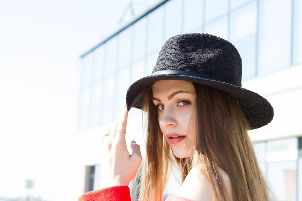 Красивая девушка в красном пальто и черной шляпе — стоковое фото