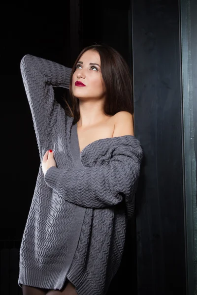 Portrait of a girl in cardigan in a dark room — Stock Photo, Image