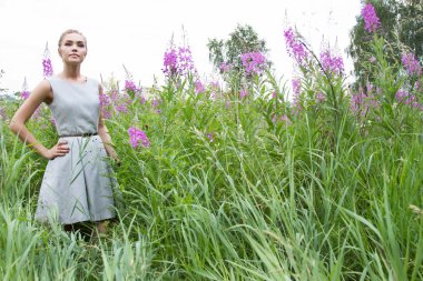 Kır çiçekleri arasında kırsal kız yürüyor