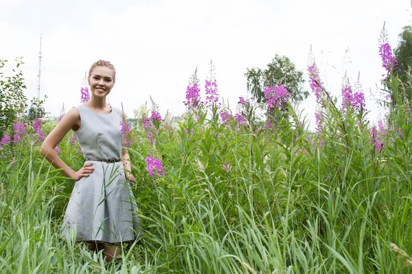 Девушка гуляет по сельской местности среди полевых цветов — стоковое фото