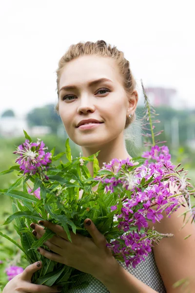 Girl walks in the countryside among wildflowers — Stock Photo, Image