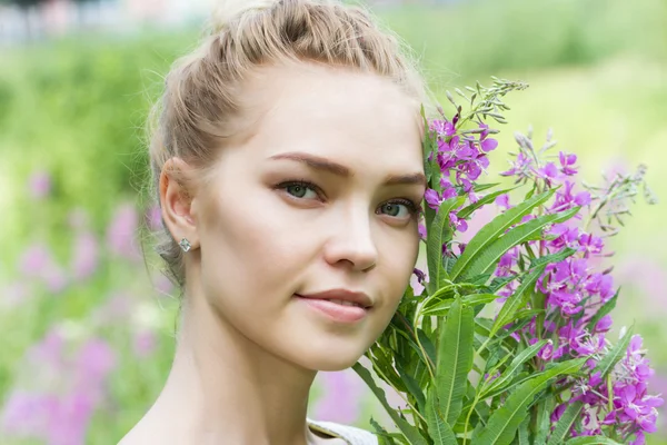 Girl walks in the countryside among wildflowers — Stock Photo, Image