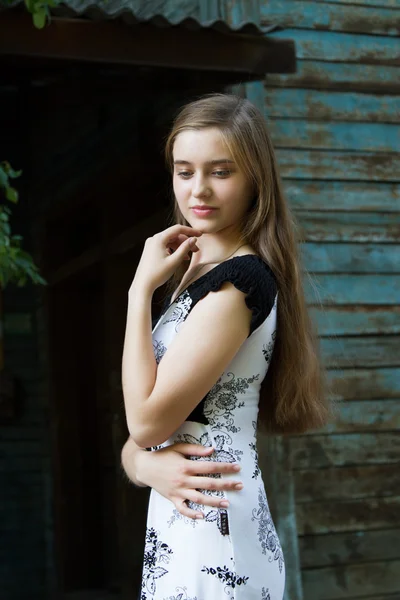 Jong meisje op de achtergrond van de oude houten gebouw — Stockfoto