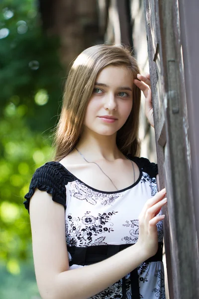 Gadis muda di latar belakang bangunan kayu tua — Stok Foto