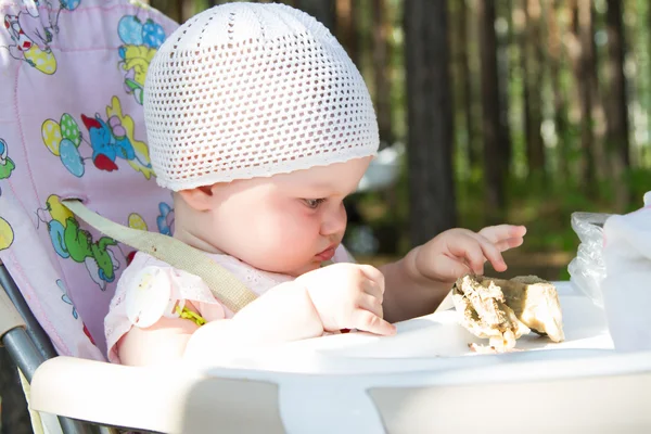 Piccolo bambino mangiare carne su un picnic — Foto Stock