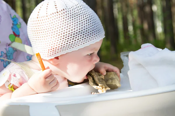 Małe dziecko jedzenie mięsa na piknik — Zdjęcie stockowe