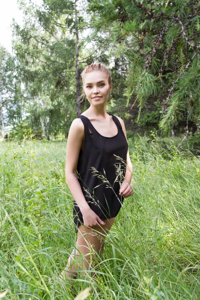 Schöne junge Blondine in einem Sommerwald — Stockfoto