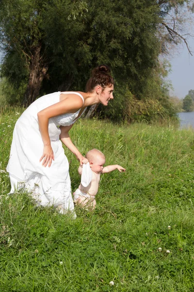 Mamá con un niño pequeño caminando en la naturaleza — Foto de Stock