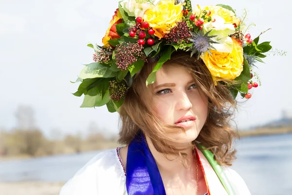 Ukrán lány, a nemzeti ruhák, és a virágok, a fején koszorút. — Stock Fotó