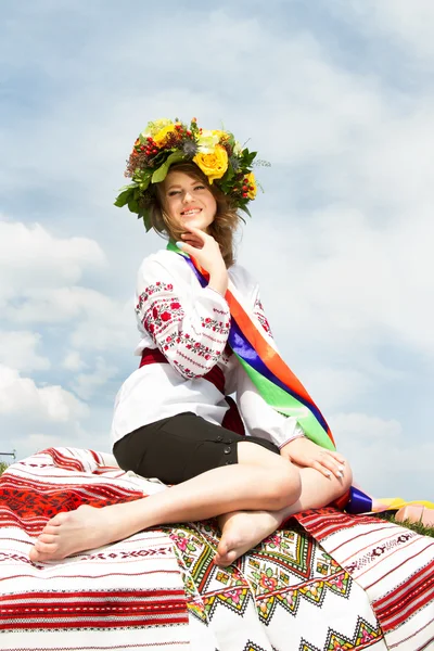 Українська дівчина в національному одязі і з квітів на її голові вінок. — стокове фото