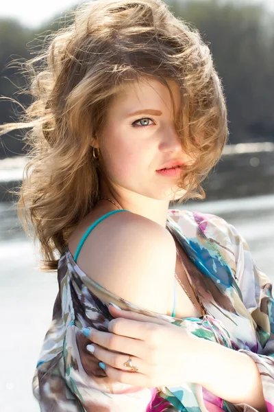 Girl on the bank of the river with developing the wind hair — Stock Photo, Image