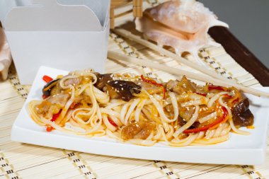 Erişte bir kağıt kapsayıcı bir arka plan üzerinde. Hazır gıda teslimini kavramı.