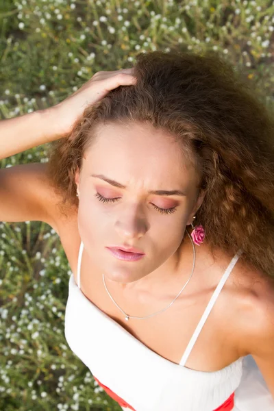 Chica rizada en el fondo de flores silvestres. Retrato de verano . — Foto de Stock