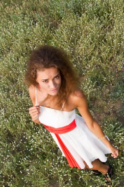 Çiçekler arasında alanındaki beyaz elbiseli kız