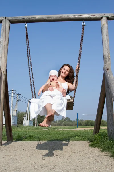 Mom with a child on a swing ride — Stock Photo, Image